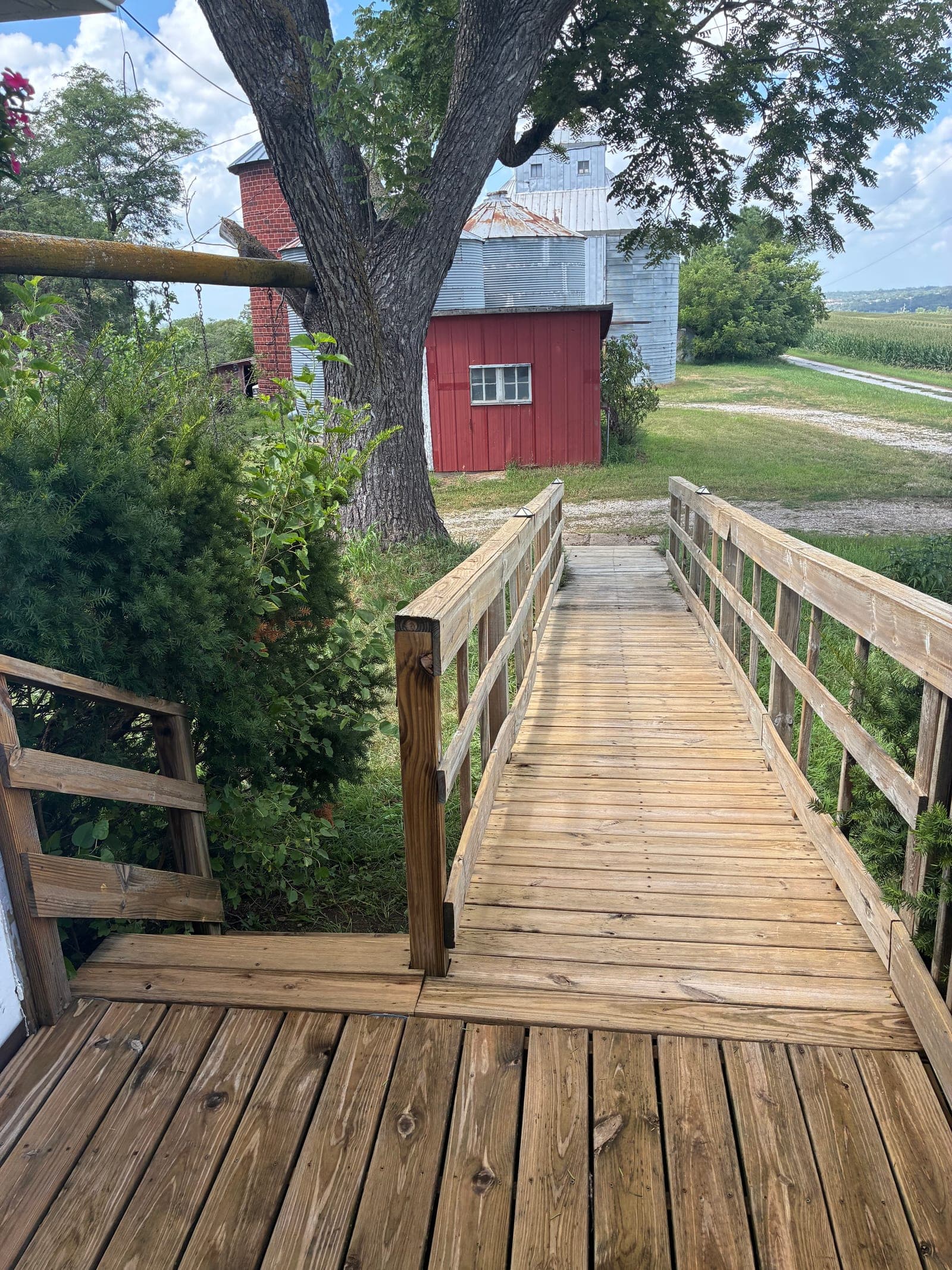 Wood ramp with handrails leading from the deck out to the yard after repair