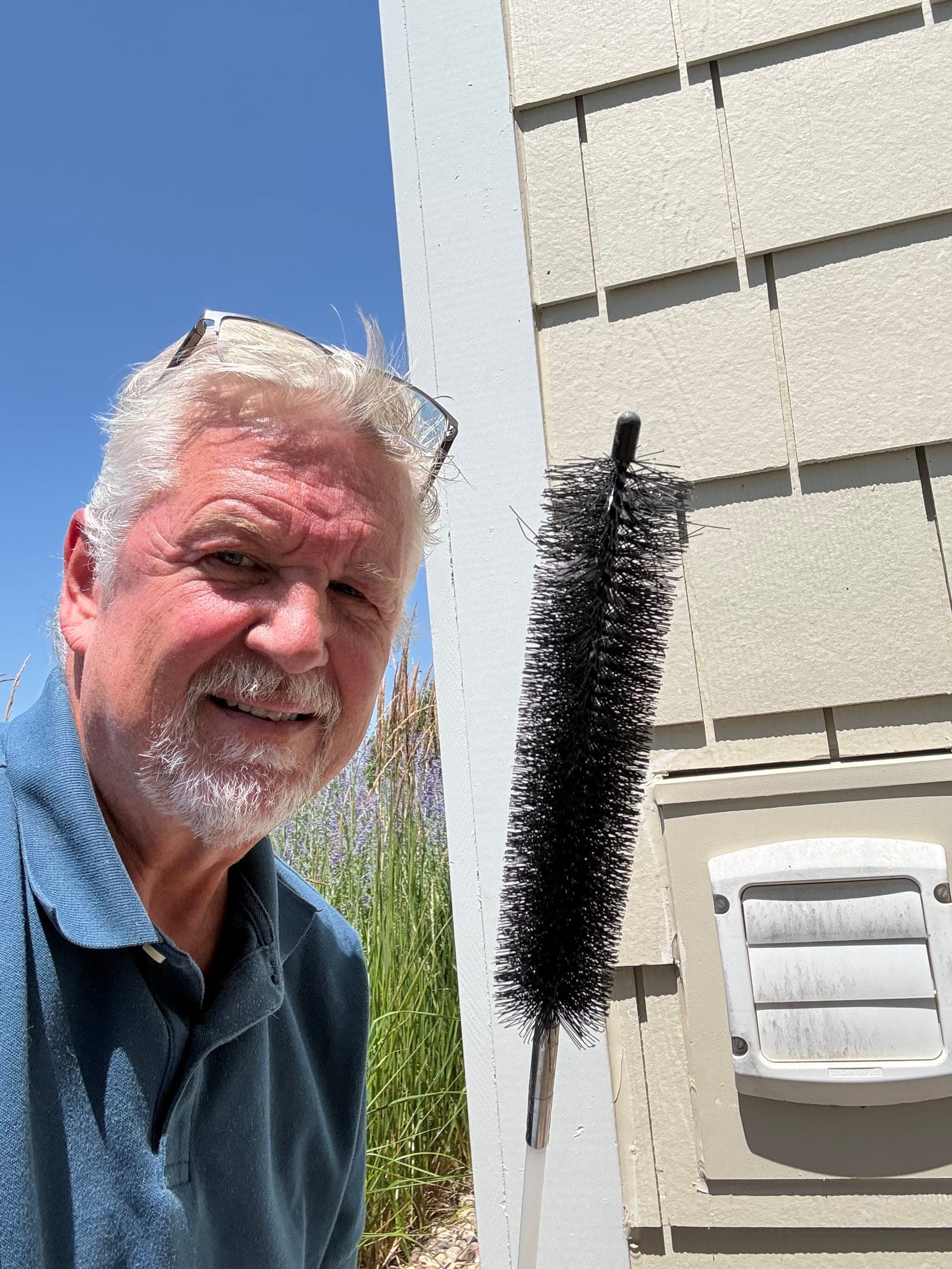Jeff with the dryer vent cleaning brush next to the exterior vent hood