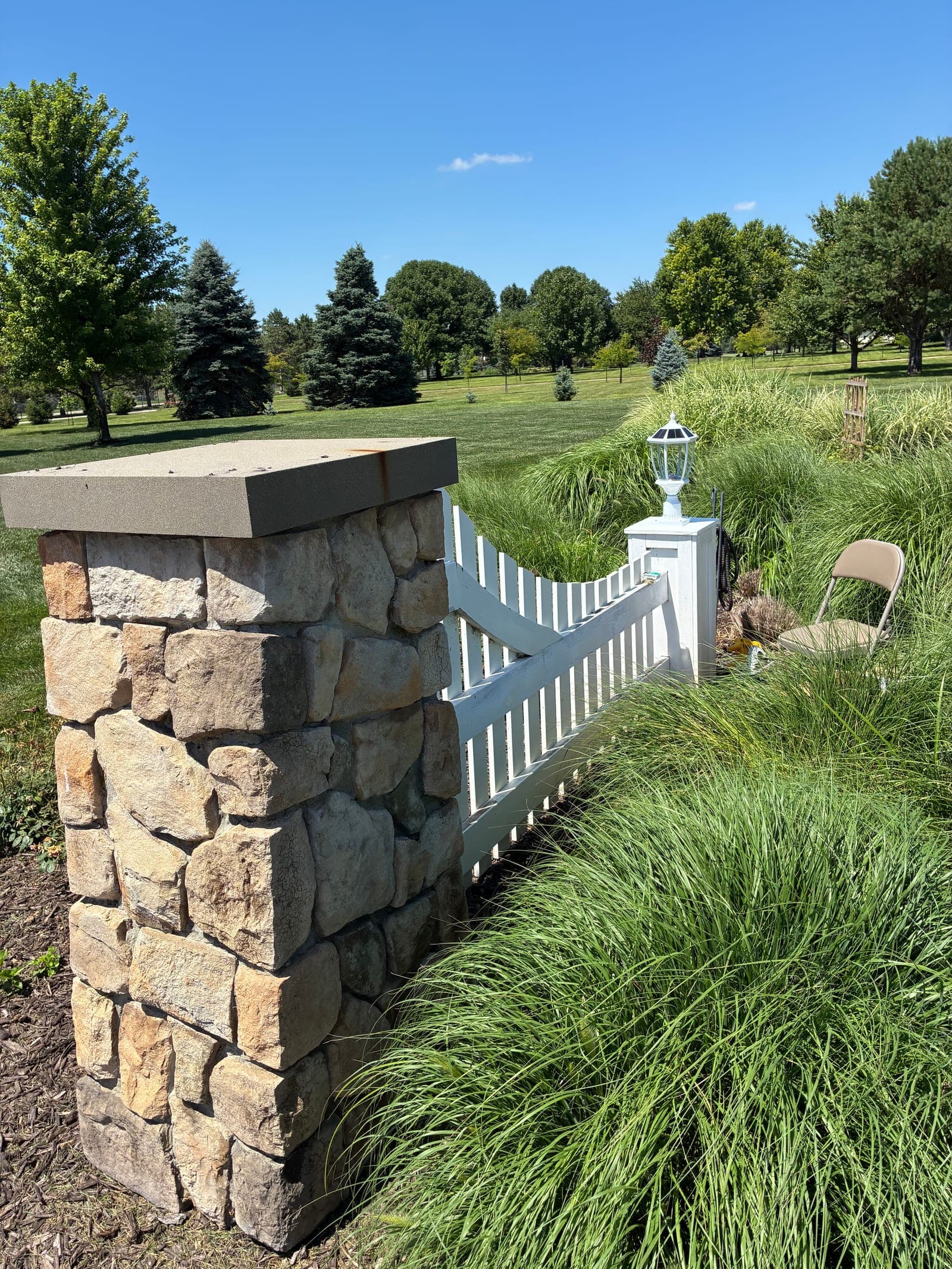 Stone wall and ramp leading up to the fence post with the new finial